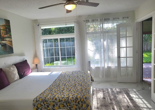 bedroom featuring ceiling fan and a textured ceiling