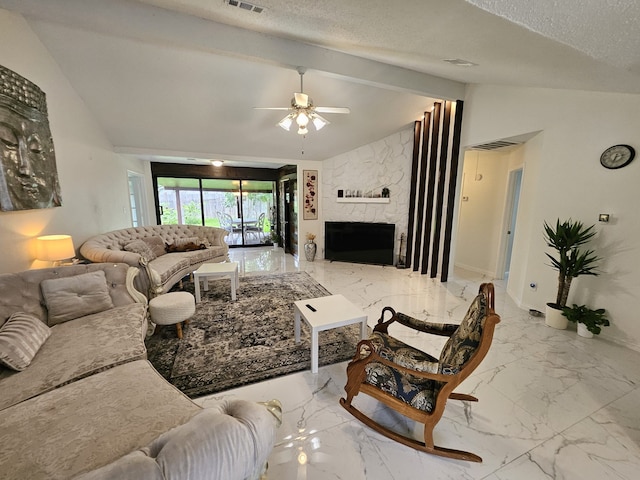 living room with ceiling fan, a fireplace, lofted ceiling with beams, and a textured ceiling