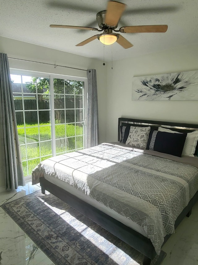 bedroom featuring ceiling fan, a textured ceiling, and multiple windows