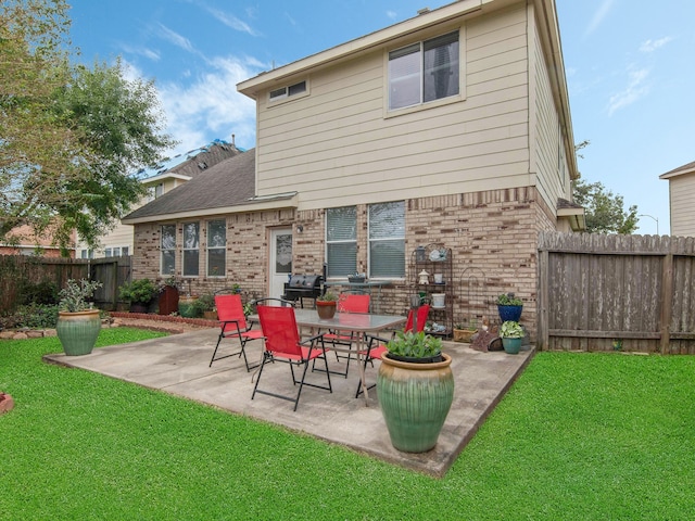 rear view of house featuring a patio and a lawn