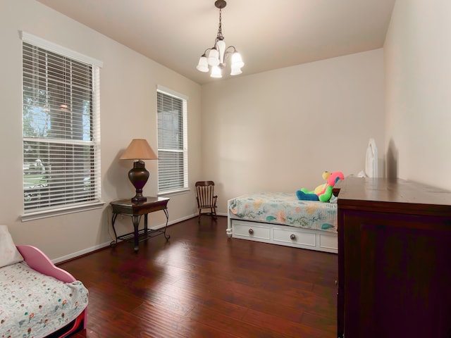 bedroom with an inviting chandelier, multiple windows, and dark wood-type flooring