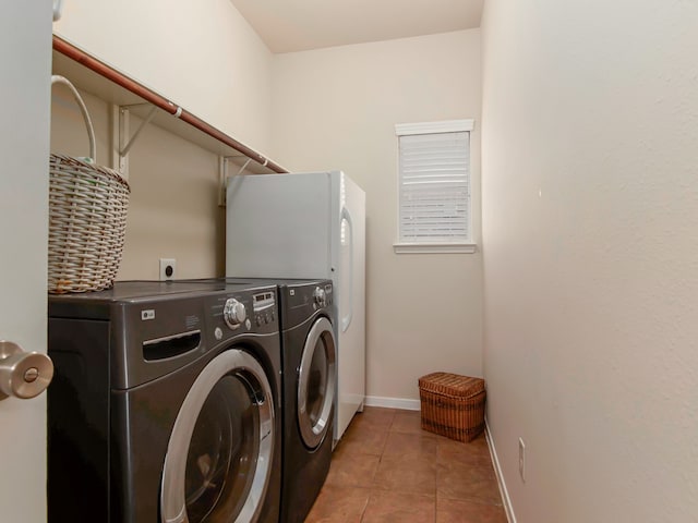 clothes washing area with washing machine and dryer and light tile patterned floors