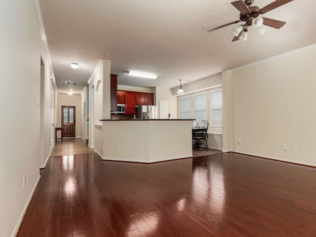 unfurnished living room with dark hardwood / wood-style flooring, ceiling fan, and ornamental molding