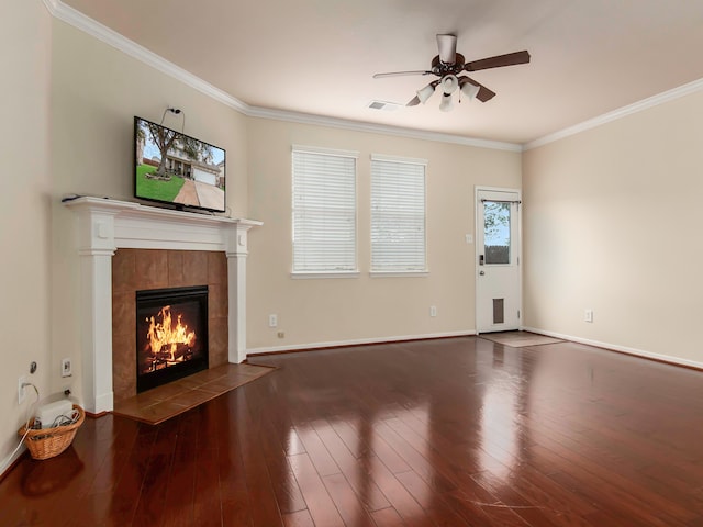 unfurnished living room with ornamental molding, ceiling fan, dark wood-type flooring, and a tiled fireplace