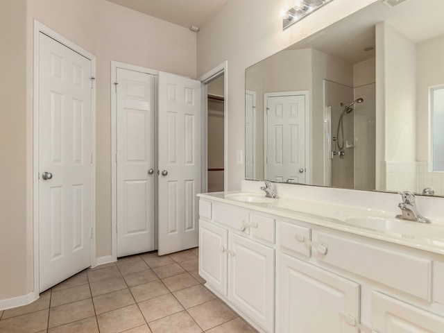 bathroom featuring tile patterned flooring, vanity, and tiled shower