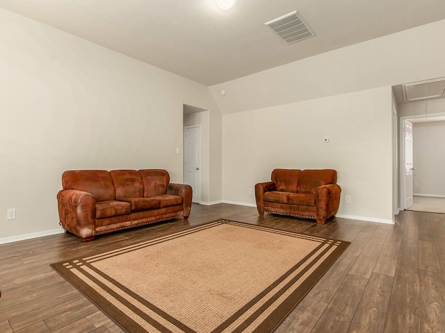 living room featuring dark hardwood / wood-style floors and vaulted ceiling