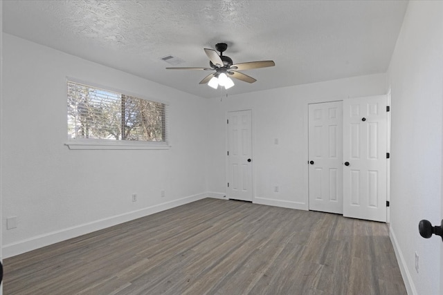 unfurnished bedroom featuring hardwood / wood-style floors, ceiling fan, and a textured ceiling