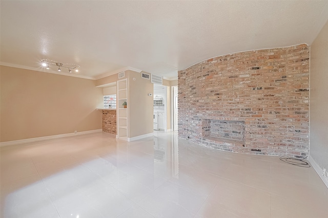 tiled empty room featuring crown molding and a textured ceiling