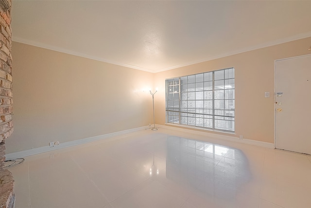 tiled spare room featuring crown molding