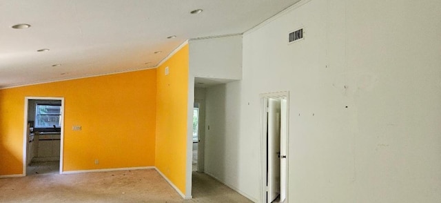 hall featuring ornamental molding, light carpet, and vaulted ceiling