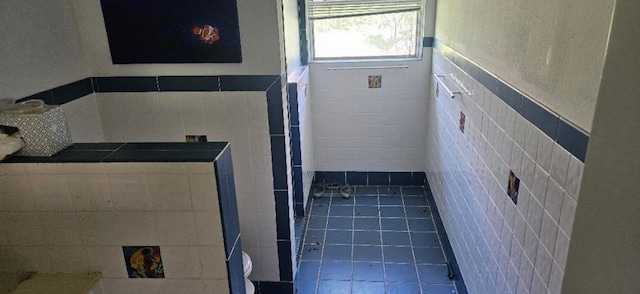 bathroom with tile patterned floors and tile walls