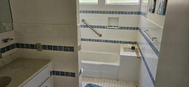 bathroom featuring shower / bathtub combination, vanity, tile walls, and tile patterned flooring