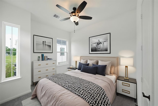 bedroom with ceiling fan, carpet floors, and multiple windows