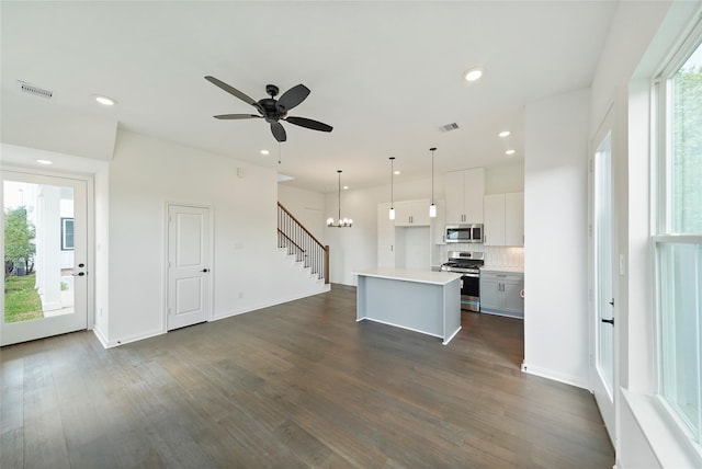 kitchen featuring decorative light fixtures, stainless steel appliances, a kitchen island, and plenty of natural light