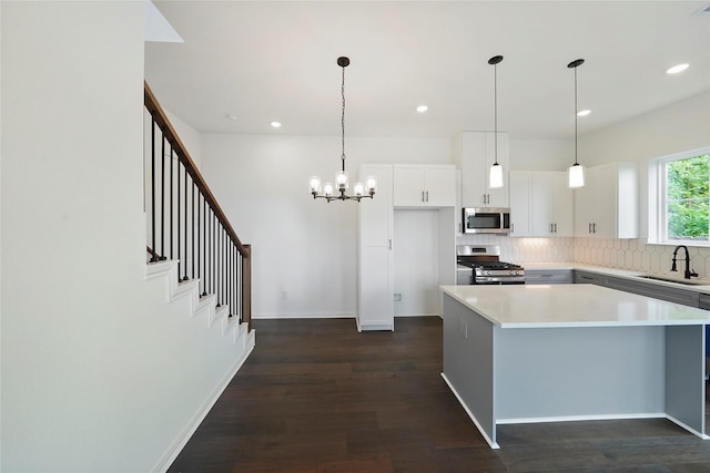 kitchen featuring dark wood-type flooring, white cabinets, stainless steel appliances, and sink