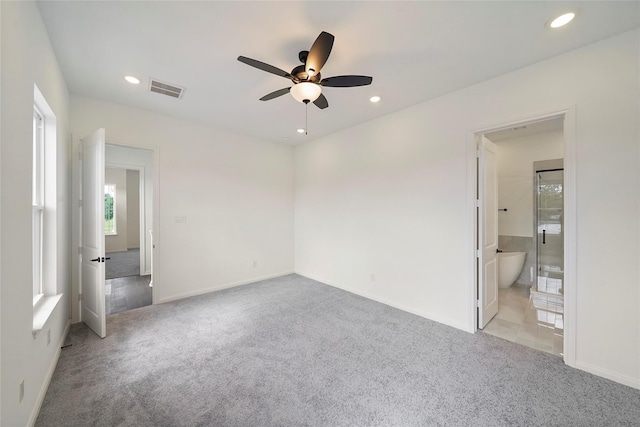 unfurnished bedroom with light colored carpet, ensuite bath, and ceiling fan