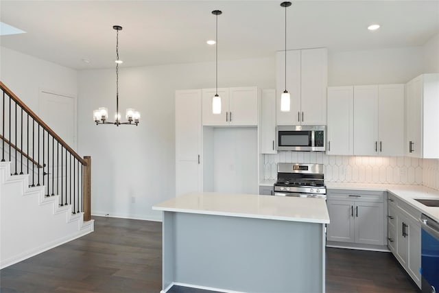 kitchen featuring pendant lighting, a center island, white cabinets, and appliances with stainless steel finishes