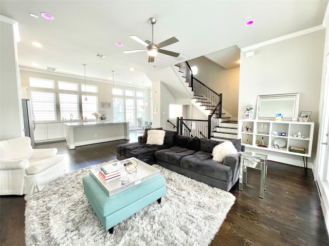 living room featuring ornamental molding, ceiling fan, and dark wood-type flooring