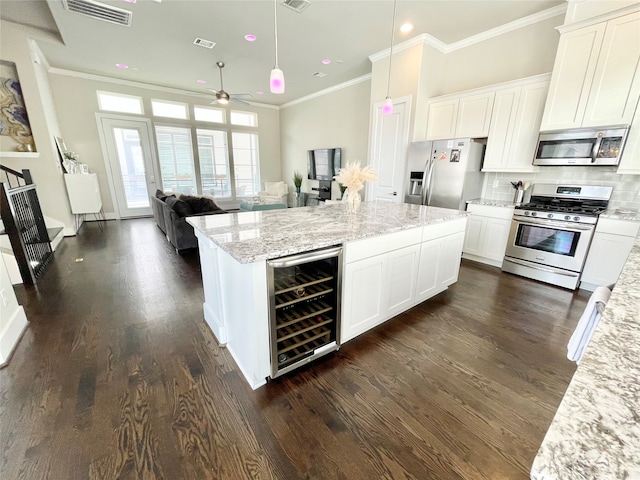 kitchen featuring white cabinetry, stainless steel appliances, and beverage cooler