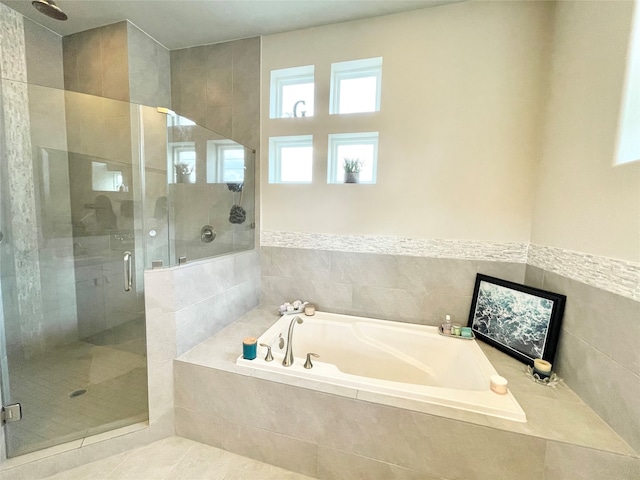 bathroom with tile patterned floors, independent shower and bath, and tile walls