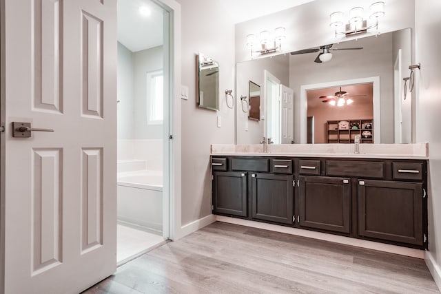 bathroom featuring a washtub, vanity, and hardwood / wood-style flooring