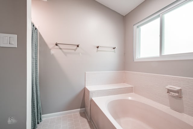 bathroom featuring tile patterned flooring and a tub to relax in