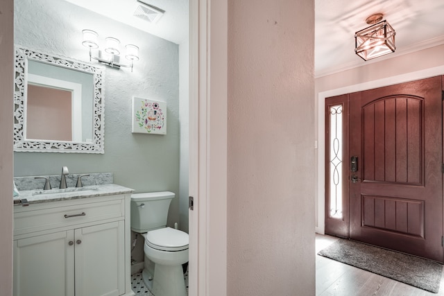 bathroom with hardwood / wood-style floors, vanity, and toilet