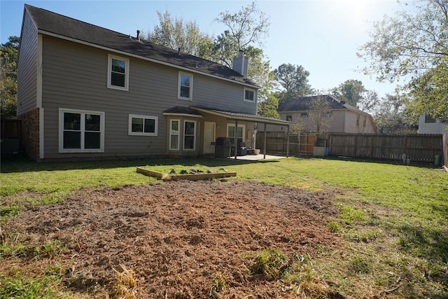 rear view of property featuring a yard and a patio area