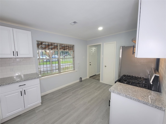 kitchen featuring light stone counters, light hardwood / wood-style flooring, and white cabinets