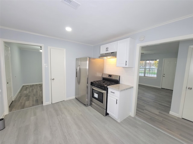 kitchen with light stone countertops, white cabinetry, stainless steel appliances, tasteful backsplash, and light hardwood / wood-style flooring