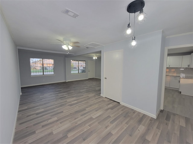 unfurnished room with ceiling fan, light wood-type flooring, and crown molding