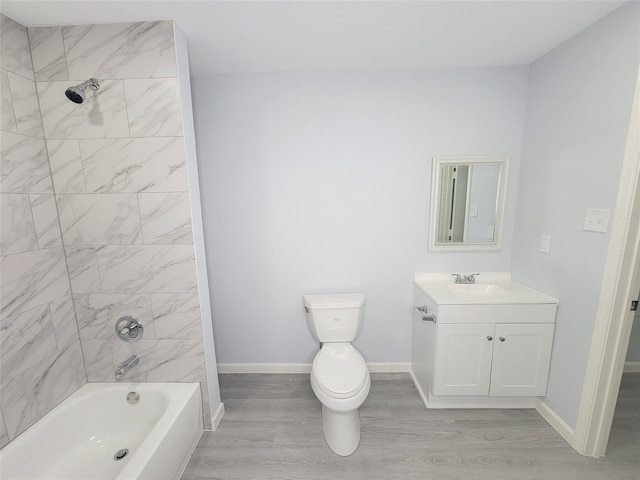 full bathroom featuring toilet, vanity, wood-type flooring, and tiled shower / bath