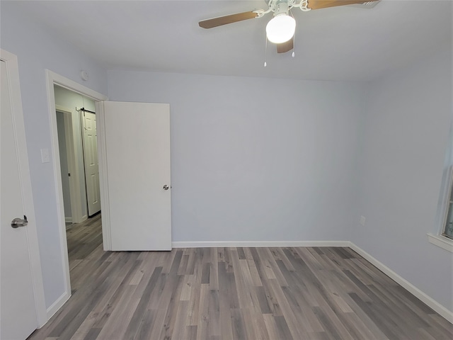 empty room with ceiling fan and light hardwood / wood-style flooring