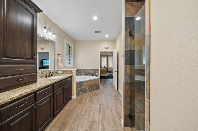 bathroom featuring vanity, wood-type flooring, and independent shower and bath