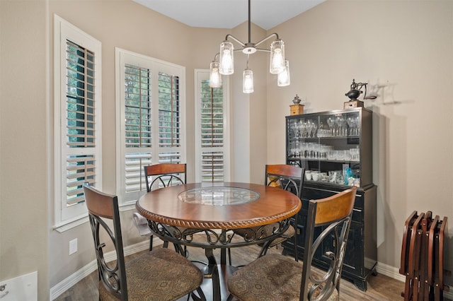 dining area featuring hardwood / wood-style flooring and a chandelier