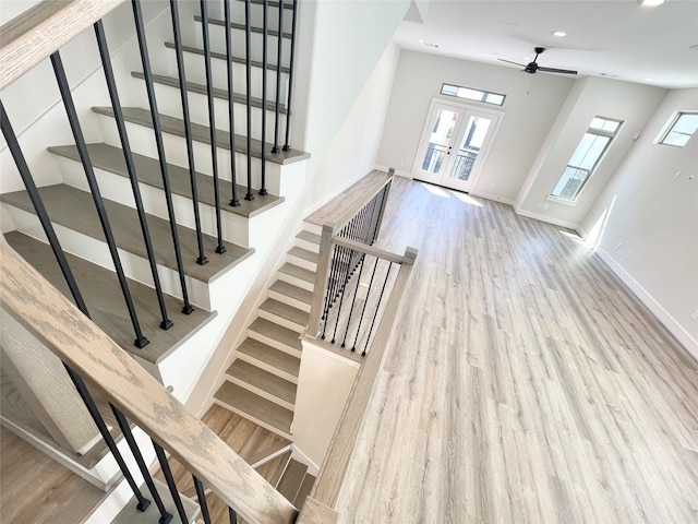 stairs featuring hardwood / wood-style flooring, ceiling fan, and french doors