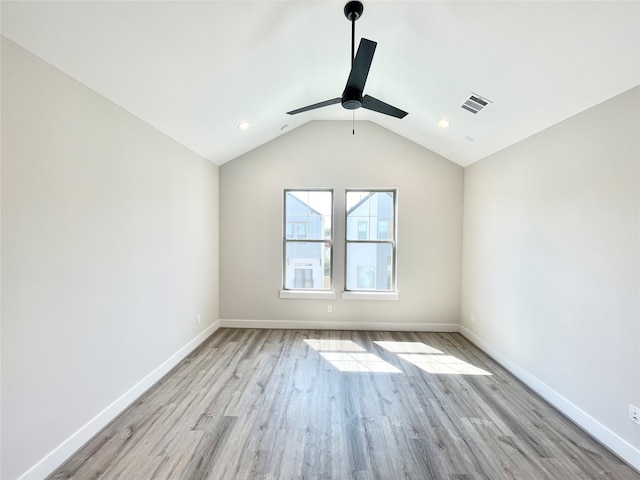 empty room featuring ceiling fan, lofted ceiling, and light wood-type flooring