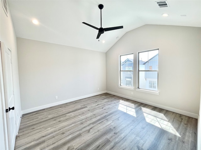 empty room with ceiling fan, light hardwood / wood-style flooring, and lofted ceiling