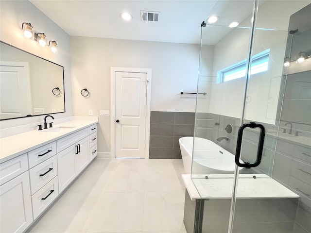 bathroom with tile patterned flooring, vanity, tile walls, and independent shower and bath