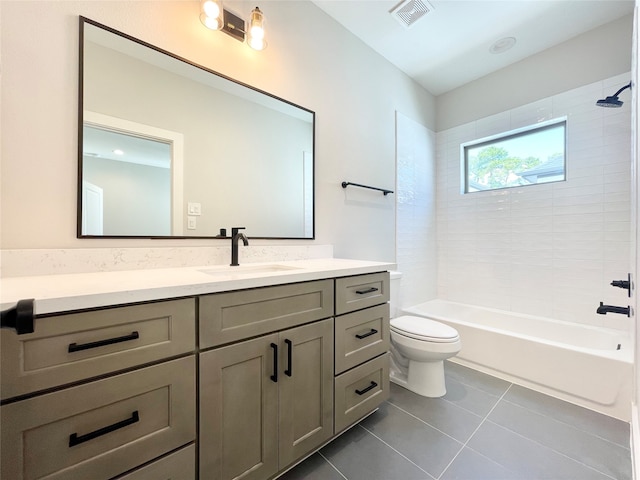 full bathroom with tile patterned floors, tiled shower / bath, vanity, and toilet