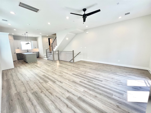 unfurnished living room featuring light wood-type flooring and ceiling fan