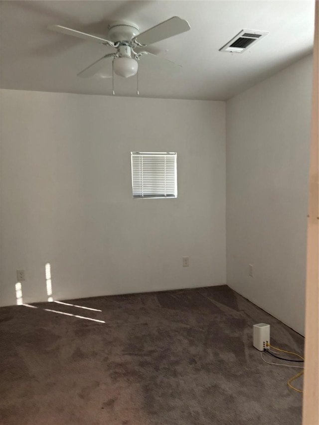 empty room featuring dark carpet and ceiling fan