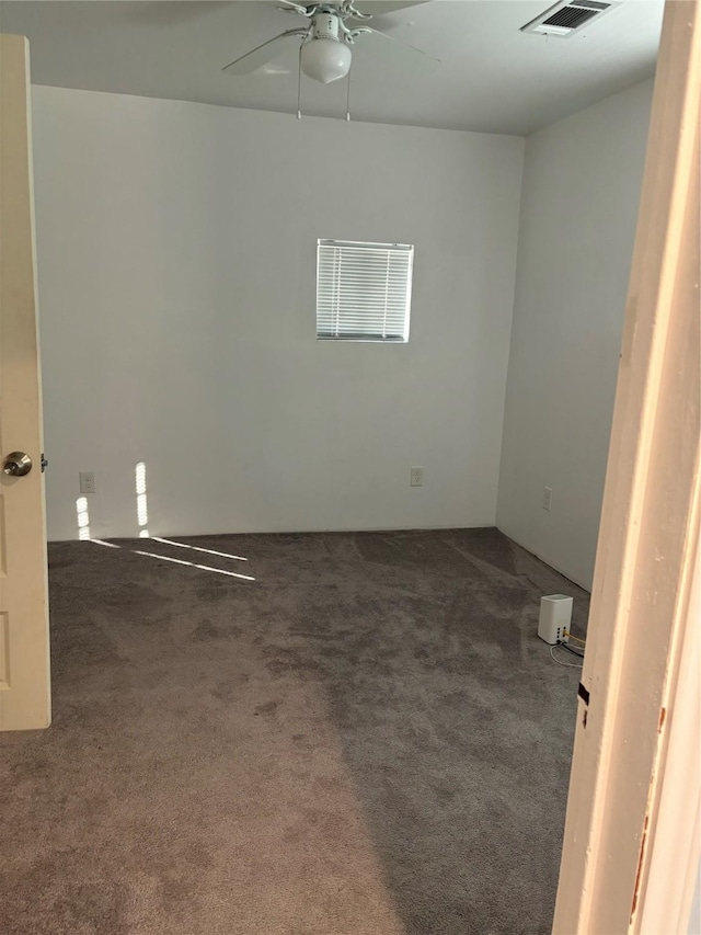 unfurnished room featuring dark carpet and ceiling fan