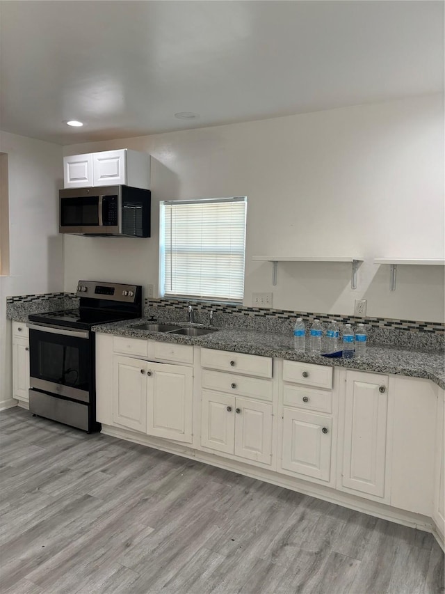 kitchen featuring white cabinetry, sink, stainless steel appliances, and light wood-type flooring