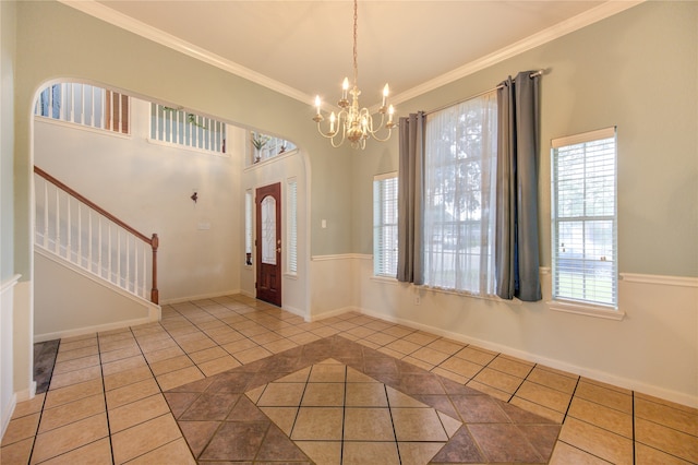 tiled entryway with a chandelier and ornamental molding