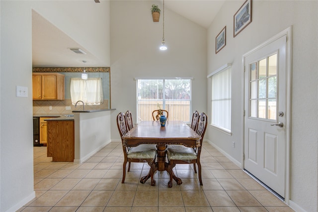 tiled dining space featuring high vaulted ceiling and a wealth of natural light