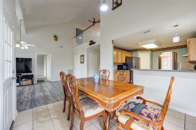 dining space featuring light hardwood / wood-style floors, high vaulted ceiling, ceiling fan, and sink