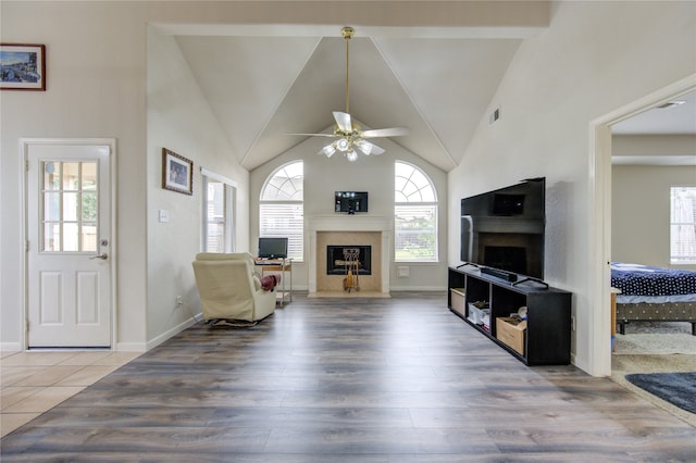 living room featuring hardwood / wood-style flooring, ceiling fan, beam ceiling, and high vaulted ceiling