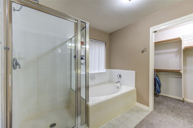 bathroom featuring separate shower and tub and a textured ceiling