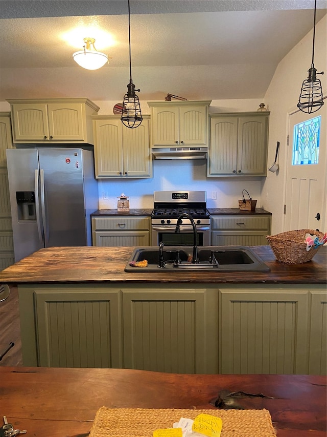 kitchen featuring sink, lofted ceiling, hanging light fixtures, and appliances with stainless steel finishes